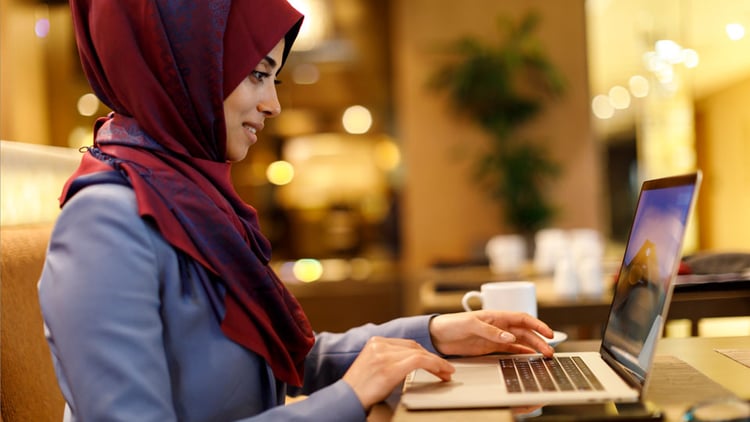 Woman on her laptop creating a shipment with UPS.