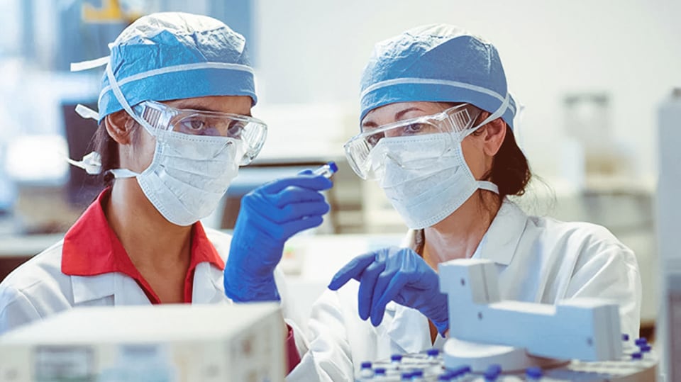 Two lab researchers looking at a lab specimen