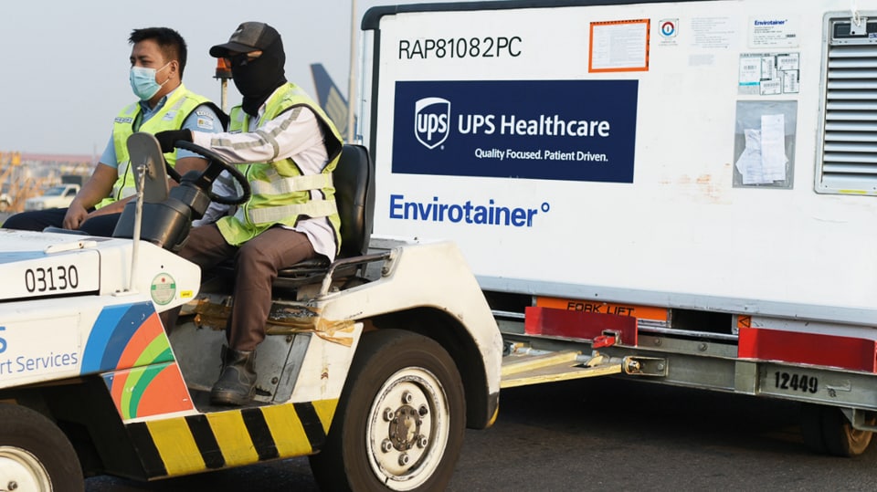 Two UPS Healthcare workers transporting critical COVID-19 vaccines.