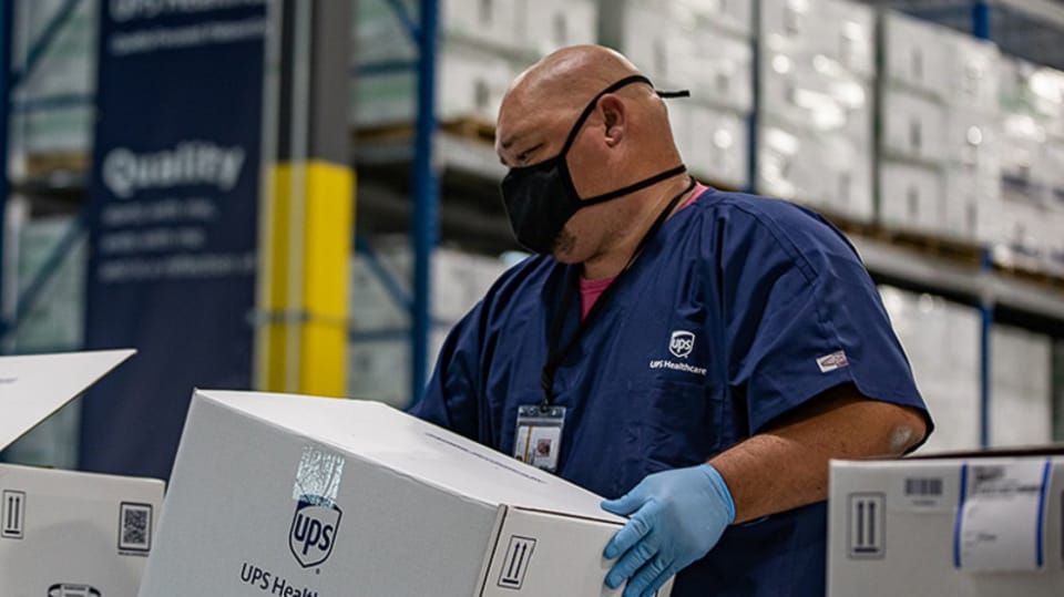 UPS Healthcare warehouse employee managing cold chain packaging