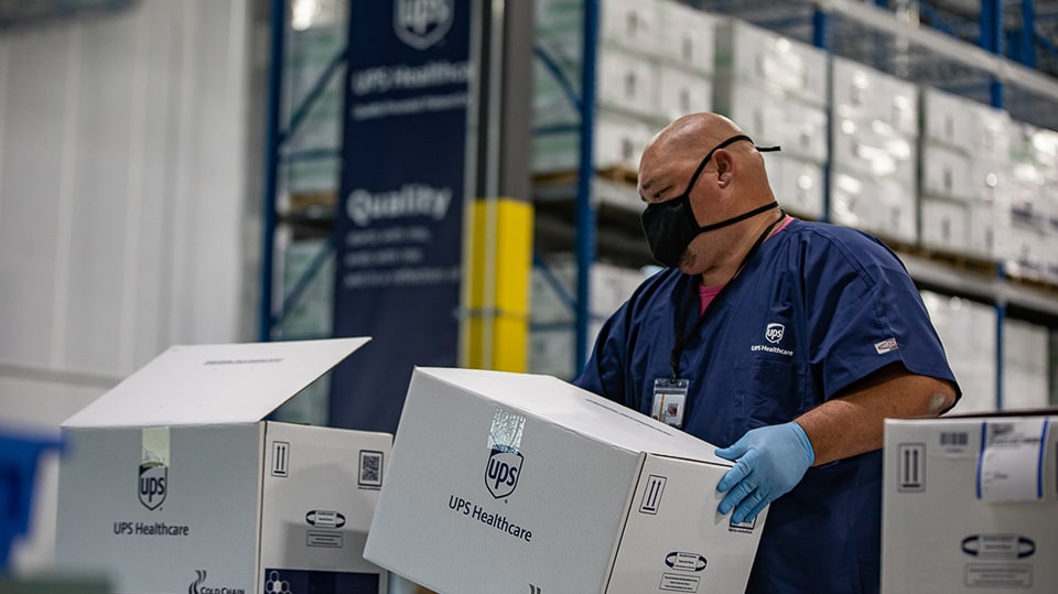 UPS Healthcare warehouse employee managing cold chain packaging