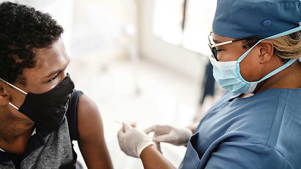 A nurse gives a COVID-19 vaccine in Malawi