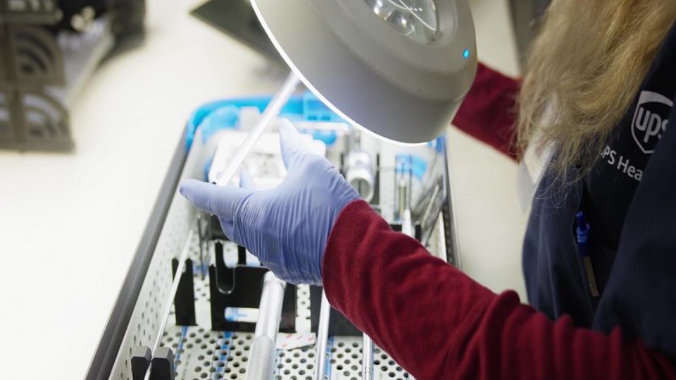 A UPS Healthcare worker inspecting surgical kit.