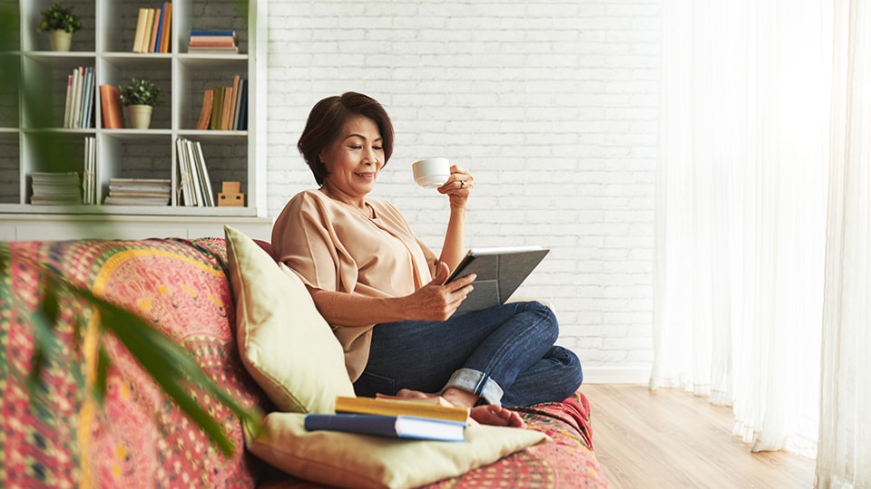 Older woman viewing shipments from tablet at home