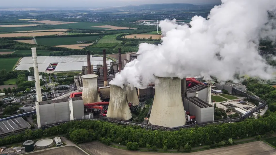 Vista aérea de una fábrica en Alemania con turbinas eólicas en segundo plano