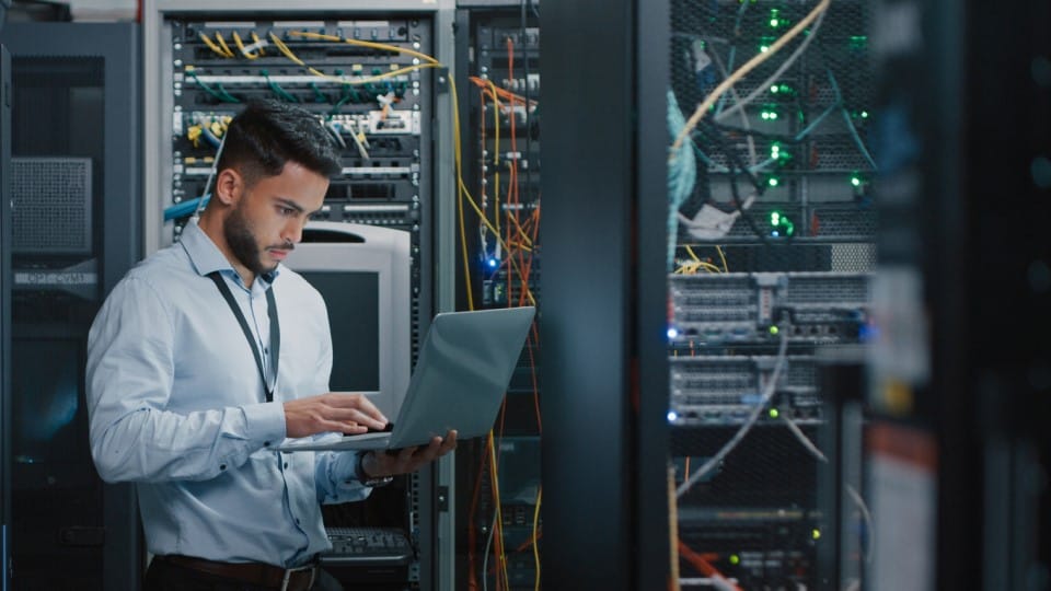 Ingeniero usando una computadora portátil en la sala de servidores