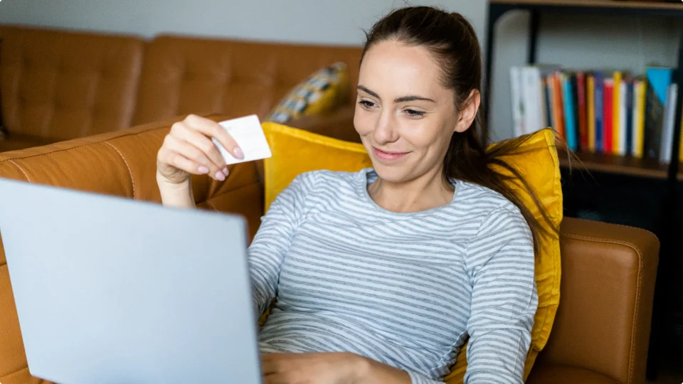 Mujer feliz haciendo compras desde el sofá