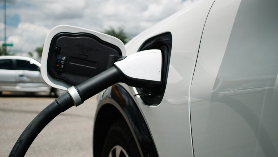 vehículo eléctrico cargándose afuera en un estacionamiento