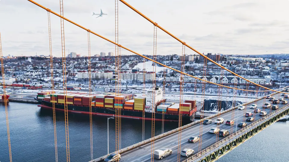 Tráfico de hora pico en un puente sobre un barco de contenedores atracado en un muelle