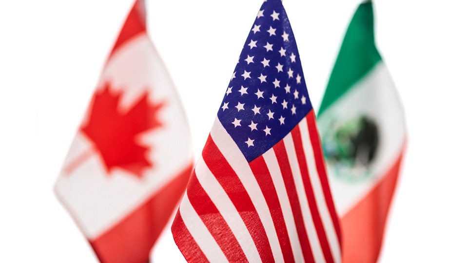 Close-up of the American Flag with the Canadian and Mexican flags behind it on a white background