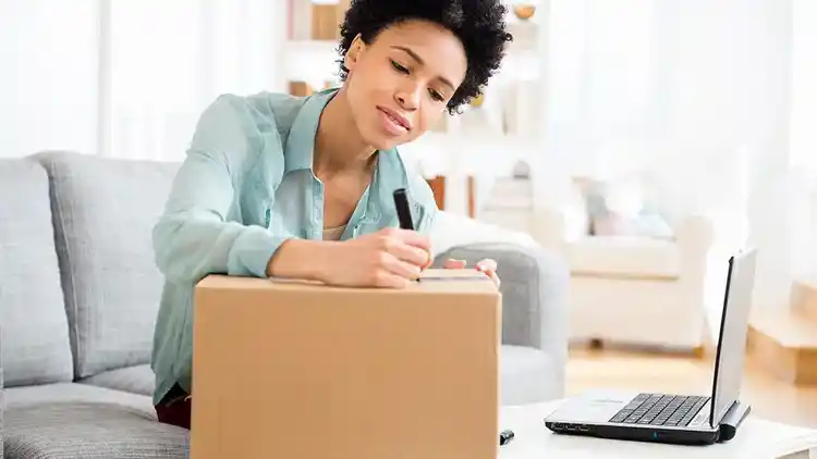 Woman writing on a box