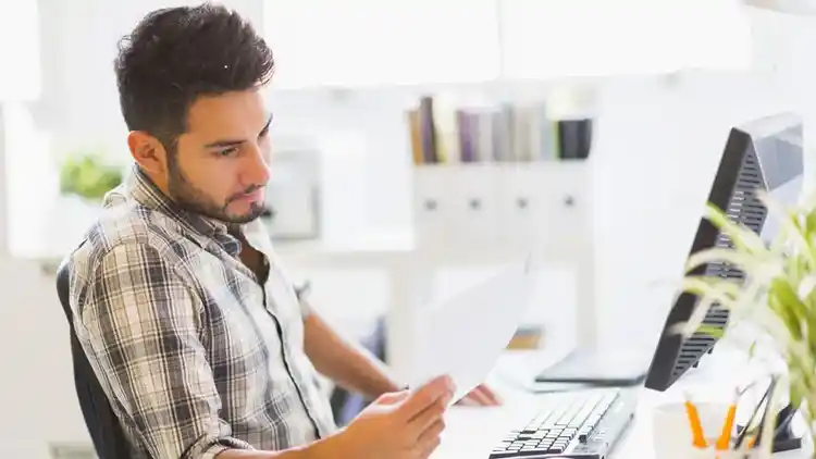 Homme propriétaire d’une petite entreprise examinant une facture