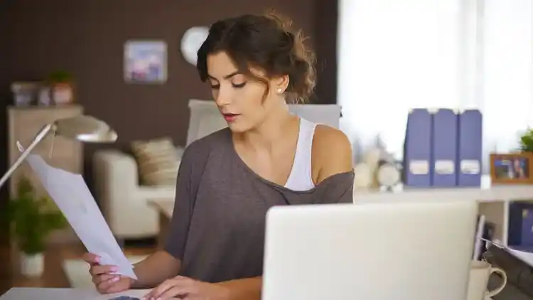 Femme propriétaire d’une petite entreprise regardant une facture