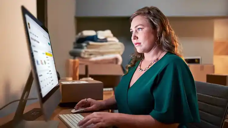 Vrouw in een groene jurk die naar een desktop kijkt