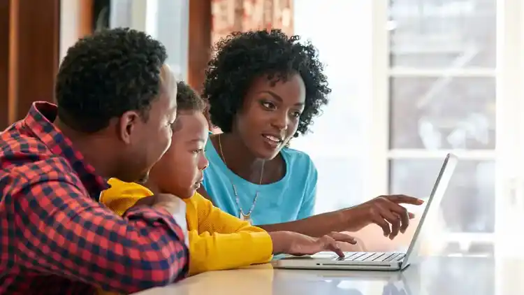 Een gezin dat naar een laptop kijkt