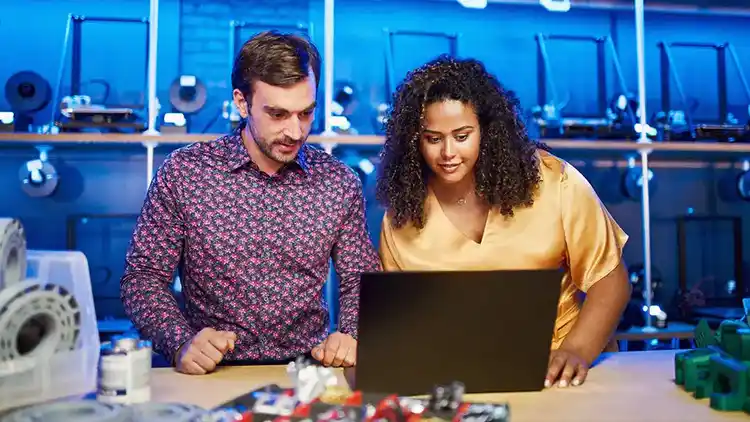 Twee mensen in een lab kijken naar een laptop