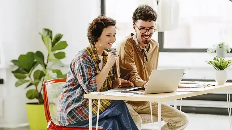 Two business owners smiling and getting a shipping discount with U-P-S