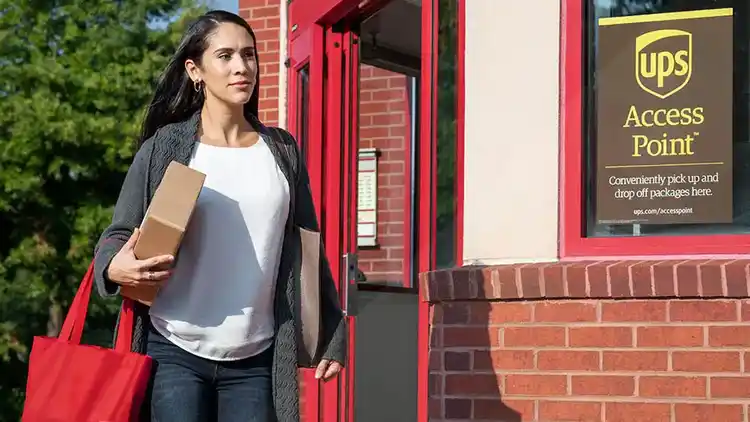 Une femme quittant un Point d’accès UPS avec un colis.