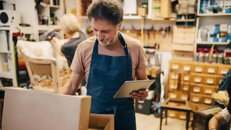 Un employé dans un magasin de détail qui utilise une tablette pour suivre les colis avec UPS My Choice.