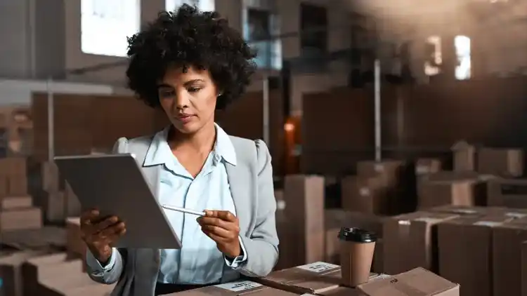 Une personne dans un entrepôt regardant sa tablette