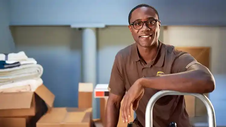 Un livreur UPS qui regarde vers l’appareil en souriant.