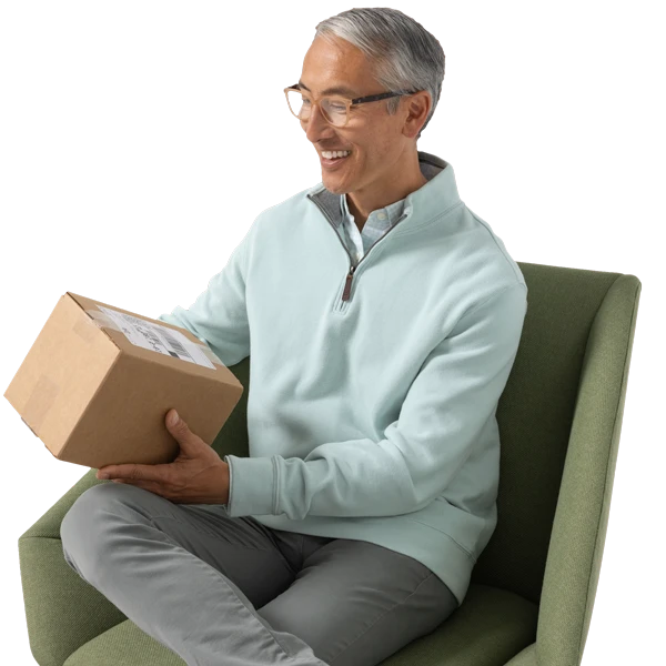 A person sitting in a chair holding a box