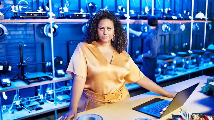 Woman stands in front of computer