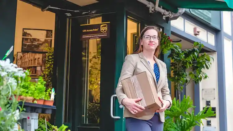 Small business owner drops of a return package at a UPS Access Point location.