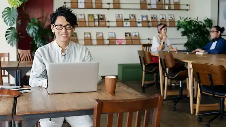 a person sitting at a coffee shop table reviewing their U P S bill