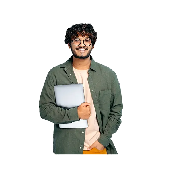 Smiling person is posed holding a computer in one hand and has their other hand in their pocket.