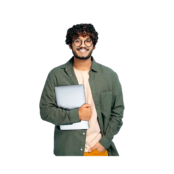 Smiling person is posed holding a computer in one hand and has their other hand in their pocket.