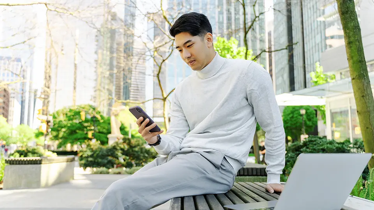 Person is outside, using cellphone to look at their U-P-S dashboard.