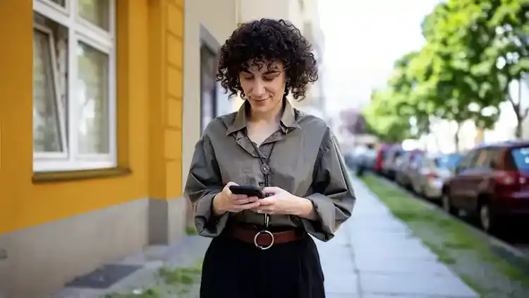 A person walking down a sidewalk looking at their phone