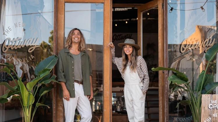 two people standing outside a storefront