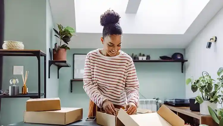 Business woman prepares package for international shipping.