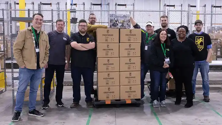 Company employees gather around packages ready to ship.