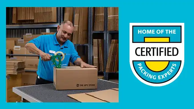 A UPS Store employee taping a box for shipment