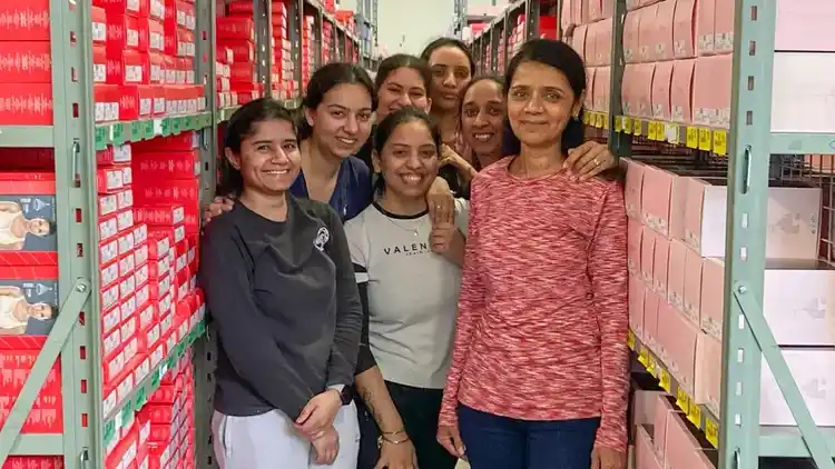 a group of people standing in a warehouse surrounded by red and pink boxes