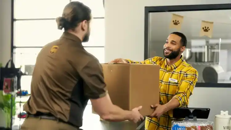 Un conductor de UPS recoge un paquete de una empresa.